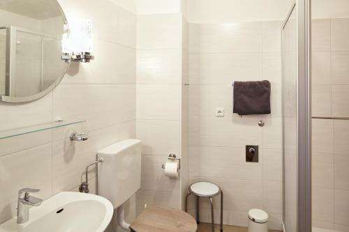 een badkamer met een wastafel, een toilet en een spiegel bij Ferienwohnung Mendgen mit Panoramablick in Bernkastel-Kues