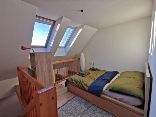 a bedroom with a bed and a staircase with windows at Kuschelige Maisonette in Lannach