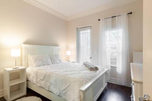 1 dormitorio blanco con 1 cama blanca y 2 ventanas en Our boutique Fort Lauderdale guest house en Fort Lauderdale