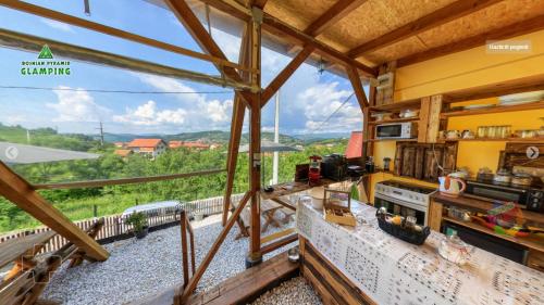 a kitchen with a view of a train on the tracks at Bosnian Pyramid Glamping in Visoko