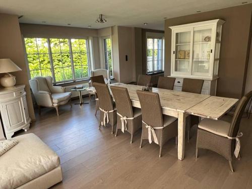 a dining room with a large wooden table and chairs at Maison Juliette in Lembeke