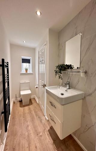 a bathroom with a white sink and a toilet at The Cottage in Saint Annes on the Sea