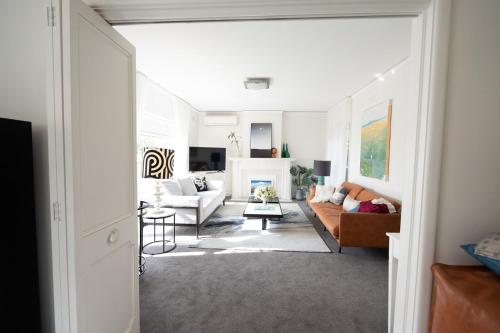 sala de estar con muebles blancos y chimenea en ToorakwhiteHouse3GrandKingBedrooms1BigGarden, en Melbourne