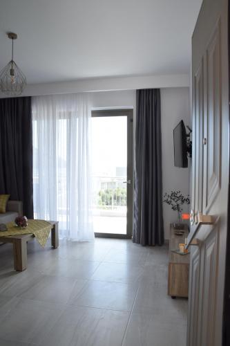 uma sala de estar com uma grande janela e um sofá em Anemoni Apartments em Plakiás