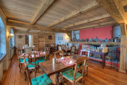 un restaurante con mesas de madera y sillas en una habitación en Locanda La Brenva - Estella Hotel Collection en Courmayeur