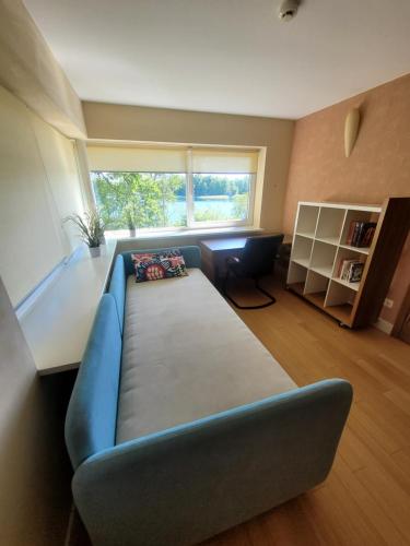 uma sala de estar com um sofá azul e uma janela em Domido Villa em Trakai