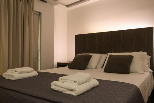 a bedroom with a bed with towels on it at Medusa Apartments in Rethymno Town
