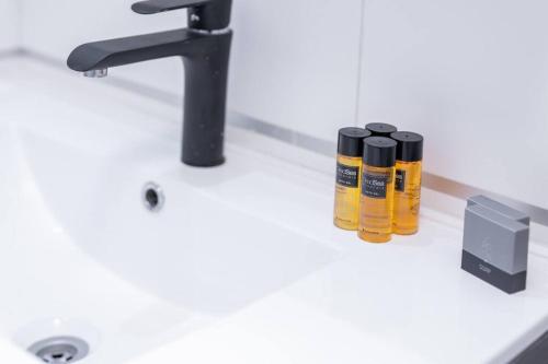 Un mostrador de baño con un lavabo con tres aceites. en O&O Group - The SeaGate Estate suites - Suite 2, en Rishon LeZion
