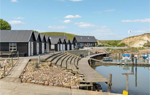 a row of black buildings next to a body of water at Holiday Home Nykobing I in Ejerslev