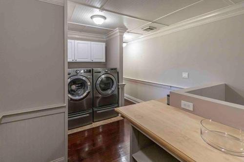 a laundry room with two washing machines and a counter at Hamptons Retreat: Near Beaches, Restaurants, Wineries in Hampton Bays