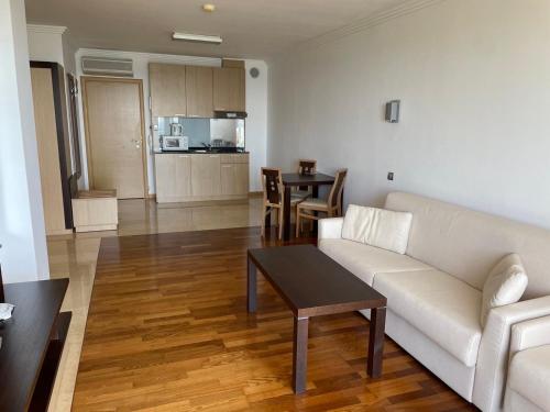 een woonkamer met een witte bank en een tafel bij private apartments in Emerald in Ravda