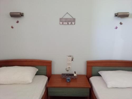 sypialnia z 2 łóżkami i szafką nocną między nimi w obiekcie Panorama Rooms w mieście Kyllini