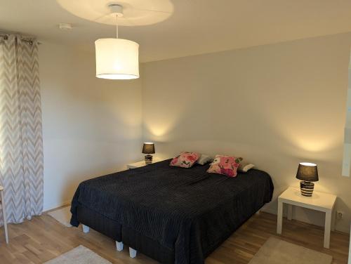 a bedroom with a bed and two tables with lamps at Kartanonrinteen Amanda in Teijo