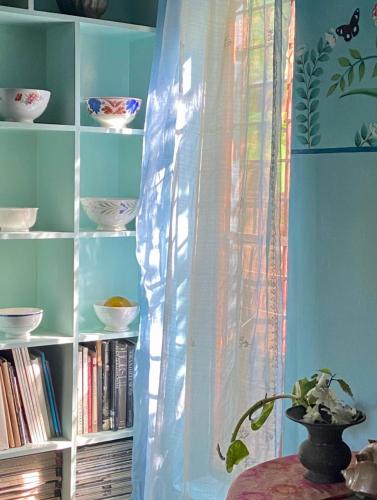 a book shelf with bowls and plates on it at Villa Jacaranda in Varkala