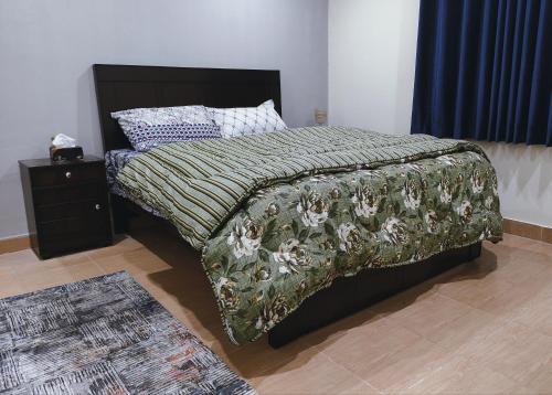 拉瓦爾品第的住宿－QB Elegant Villa Bahria Town，一间卧室配有一张带毯子和床头柜的床