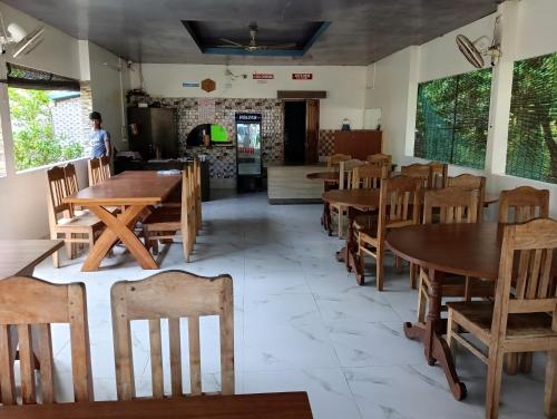 uma sala de jantar com mesas e cadeiras de madeira em Dream Valley Resort em Neil Island