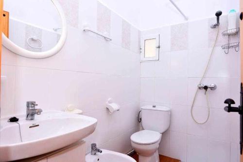 een witte badkamer met een wastafel en een toilet bij Cortijo Algarrobo Casa de Campo tranquila in Carboneras