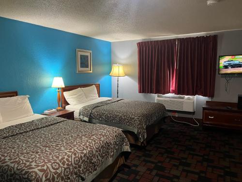 ein Hotelzimmer mit 2 Betten und einem TV in der Unterkunft Rodeway Inn in Whitehall