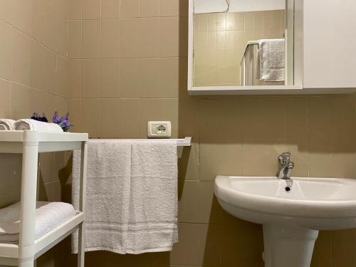 a bathroom with a sink and a mirror and towels at Frontemare Residence in Fiumefreddo di Sicilia