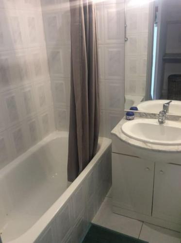 La salle de bains est pourvue d'un lavabo et d'une baignoire à côté d'un lavabo. dans l'établissement Jolie petite villa climatisée proche de la mer, à Torreilles