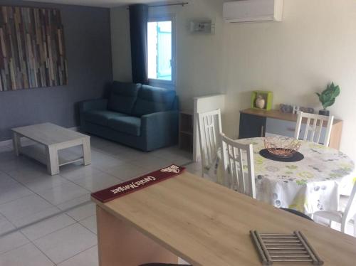 cocina y sala de estar con mesa y sillas en Jolie petite villa climatisée proche de la mer, en Torreilles