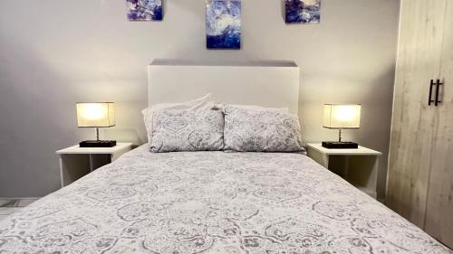 ein Schlafzimmer mit einem weißen Bett mit zwei Lampen in der Unterkunft Habitacion Plata# 1 in Aguascalientes