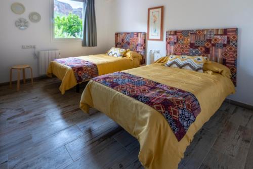 TenteniguadaにあるVilla Los Naranjosのベッド2台と窓が備わるホテルルームです。