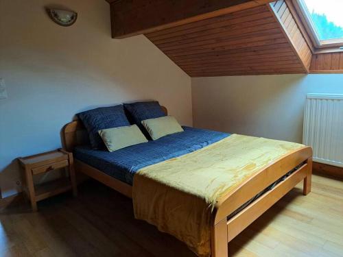 um quarto com uma cama com lençóis azuis e uma janela em Maison Landes - Gite 4 personnes em Latouille-Lentillac