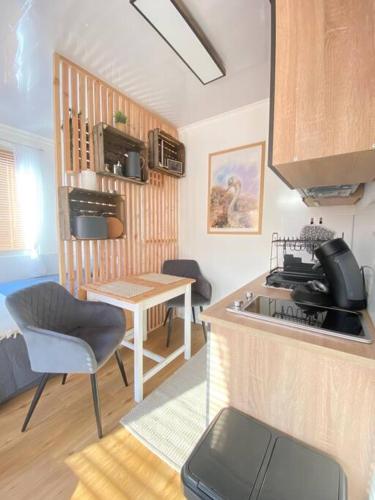 a kitchen with a sink and a table with a chair at Tiny Haus Straußenblick 2 in Bad Fallingbostel
