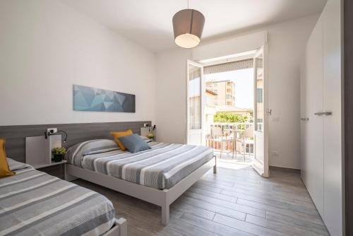 a bedroom with two beds and a sliding glass door at Le Case di Salvia in San Vincenzo