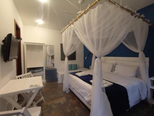 パラチにあるMagias de Paraty Ecopousadaのベッドルーム(天蓋付きベッド1台付)