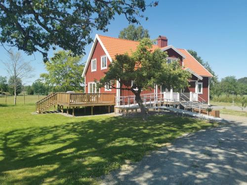 a large red house with a large wooden deck at Äppelgården in Sollebrunn