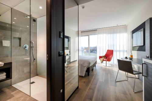 a bedroom with a bed and a bathroom with a shower at Life Hotel in Bergamo