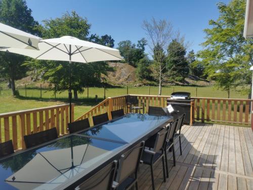 a patio with a table and chairs and an umbrella at Äppelgården in Sollebrunn
