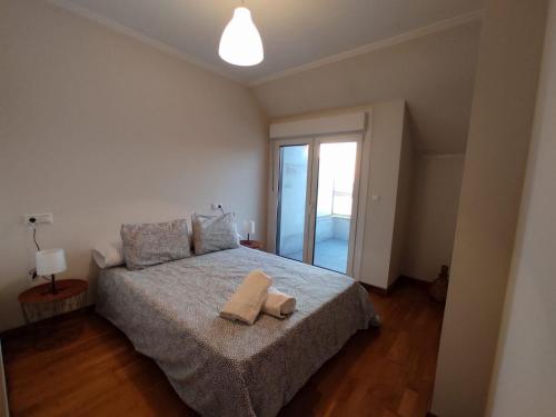 een slaapkamer met een bed met twee handdoeken erop bij Apartamento Vistas a ensenada in Meaño