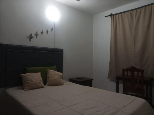 um quarto com uma cama com uma luz na parede em La torre 22 em Santiago del Estero