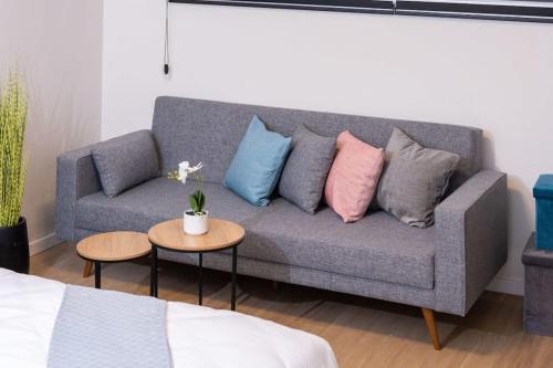 sala de estar con sofá y almohadas en O&O Group - The SeaGate Estate suites - Suite 1 en Rishon LeẔiyyon