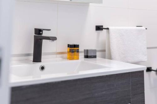 baño con lavabo blanco con grifo en O&O Group - The SeaGate Estate suites - Suite 1 en Rishon LeẔiyyon