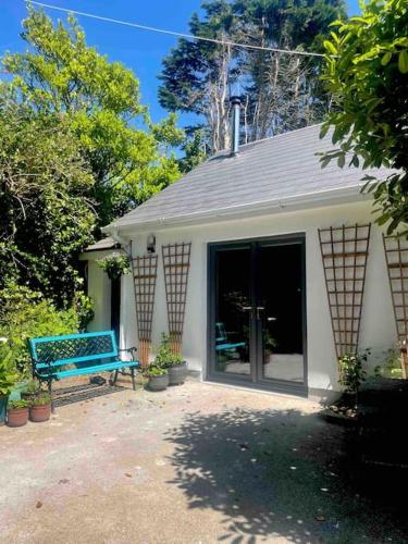 a building with a blue bench in front of it at Railway cottage Annascaul in Anascaul