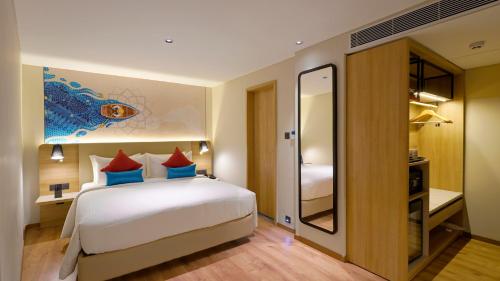 a hotel room with a bed and a mirror at Aiden by Best Western Hennur Bengaluru in Bengaluru