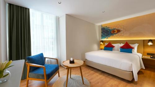 a hotel room with a bed and a chair at Aiden by Best Western Hennur Bengaluru in Bengaluru