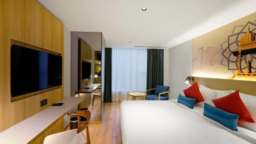 a hotel room with a bed and a tv at Aiden by Best Western Hennur Bengaluru in Bengaluru
