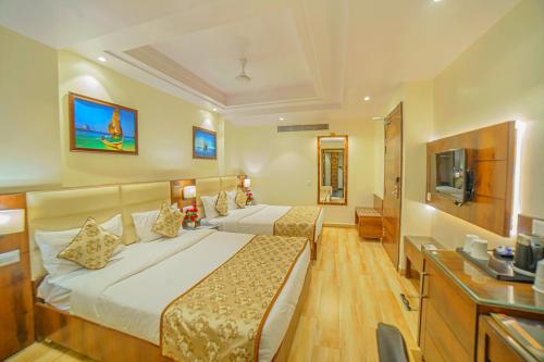 アラハバードにあるHotel Hira Inn-10mins From Railway Station & Bus Stationのベッド2台とテレビがあるホテルの部屋