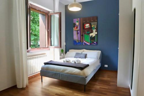 uma cama num quarto com uma parede azul em A due passi dal Centro & Parcheggio Gratuito em Turim