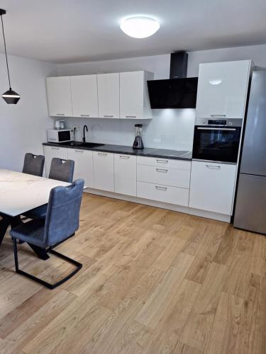 a kitchen with white cabinets and a table and a refrigerator at Guesthouse Flower in Ljubljana