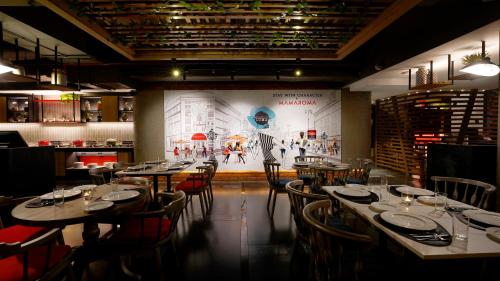 a dining room with tables and chairs and a mural at Aiden by Best Western Hennur in Bangalore