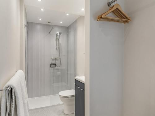 a white bathroom with a shower and a toilet at The Hideaway At The Morley in Torquay