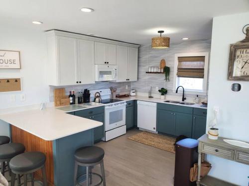 a kitchen with blue and white cabinets and a counter at The Lost Loggerhead- OBX Ocean view Beach House in Avon