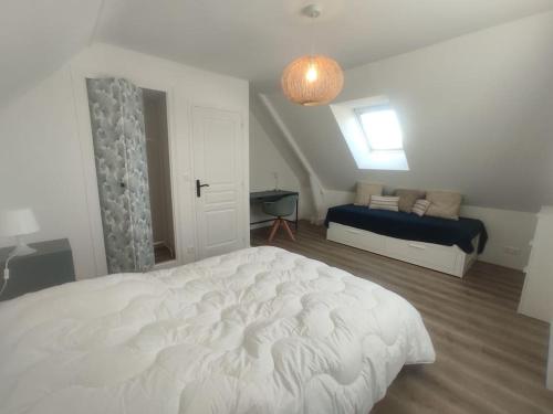 une chambre avec un grand lit blanc et une fenêtre dans l'établissement Maison 7 pers. à 1km de la plage, à La Baule