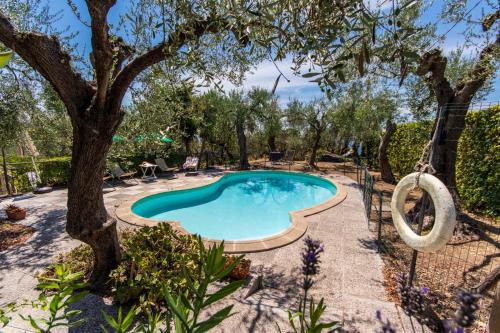 a swimming pool in a yard with a tree at Le Navi In Cielo in Imperia